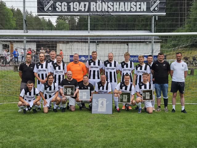 Mannschaftsfoto der SG Rönshausen vor dem Vereinsbanner